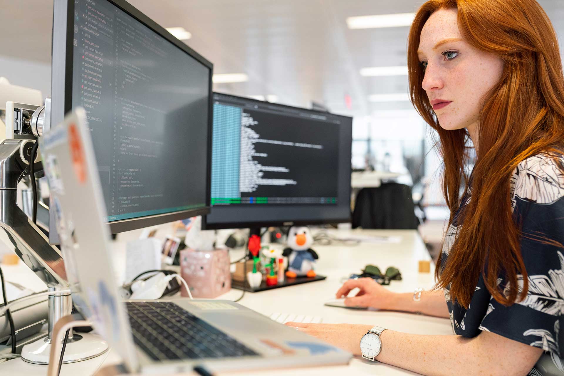 A woman sitting at her desk looking at the computer screen.