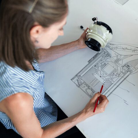 A woman drawing on top of a table.