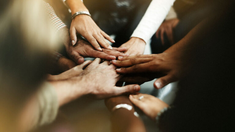 A group of people with their hands together.