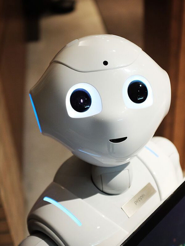 A robot is holding a tablet in its hands.