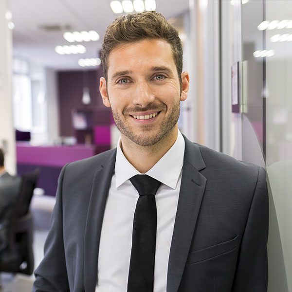 A man in suit and tie smiling for the camera.