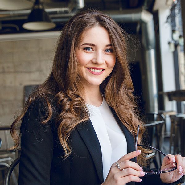 A woman in black jacket holding a pen.