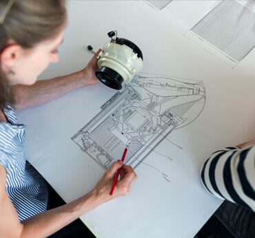 A woman drawing on top of a table.