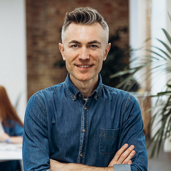 A man with his arms crossed in front of some people.