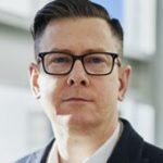 A man with glasses and a suit jacket.