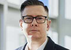 A man with glasses and a suit jacket.