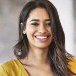 A woman with long hair smiles for the camera.
