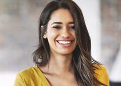 A woman with long hair smiles for the camera.
