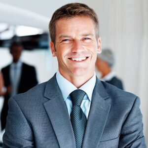 A man in suit and tie smiling for the camera.