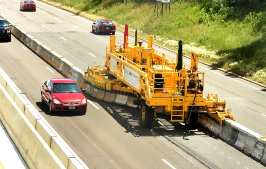 A red car is driving down the road