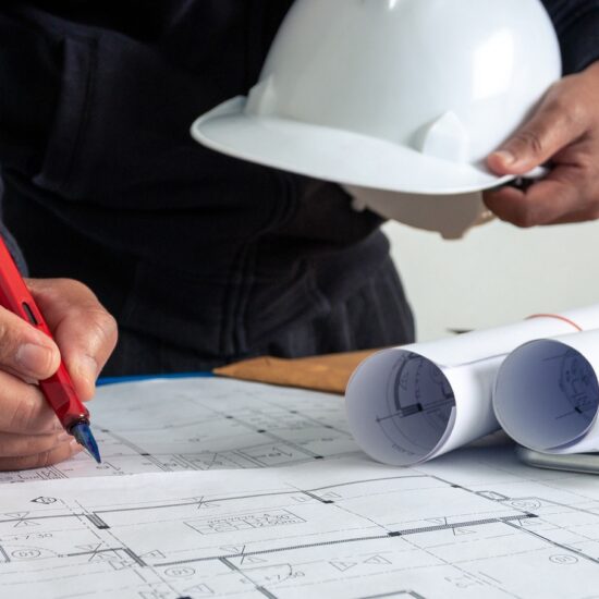 A person with a hard hat and some plans